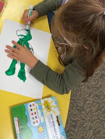 a little girl drawing on a sheet of paper